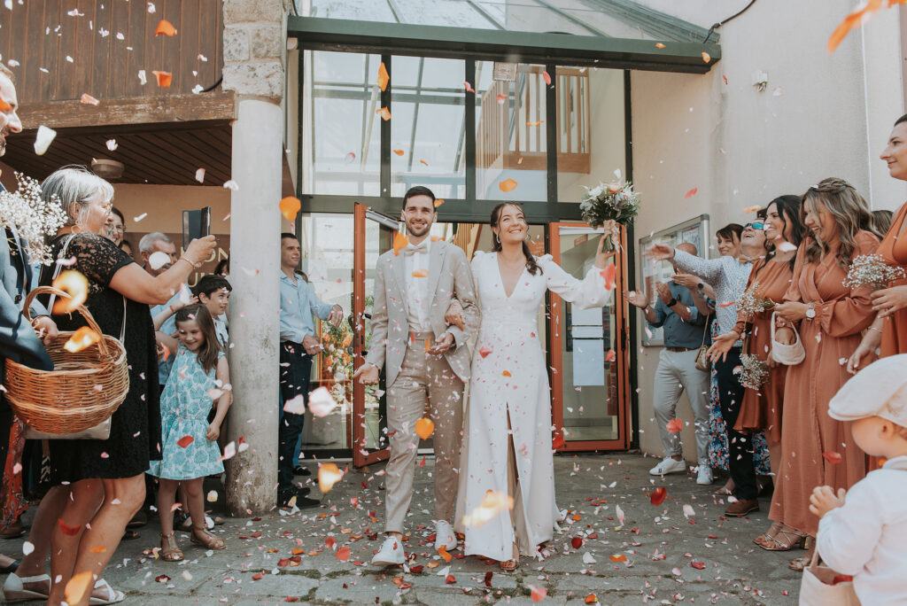 Un couple de marié sortant de la mairie et entourés d'invités photographié par LD photographie à Quimper.