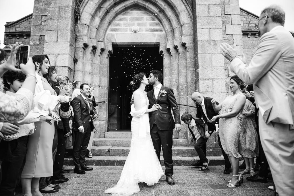 Photographie de deux mariés en noir et blanc devant l'église de Brest en Bretagne